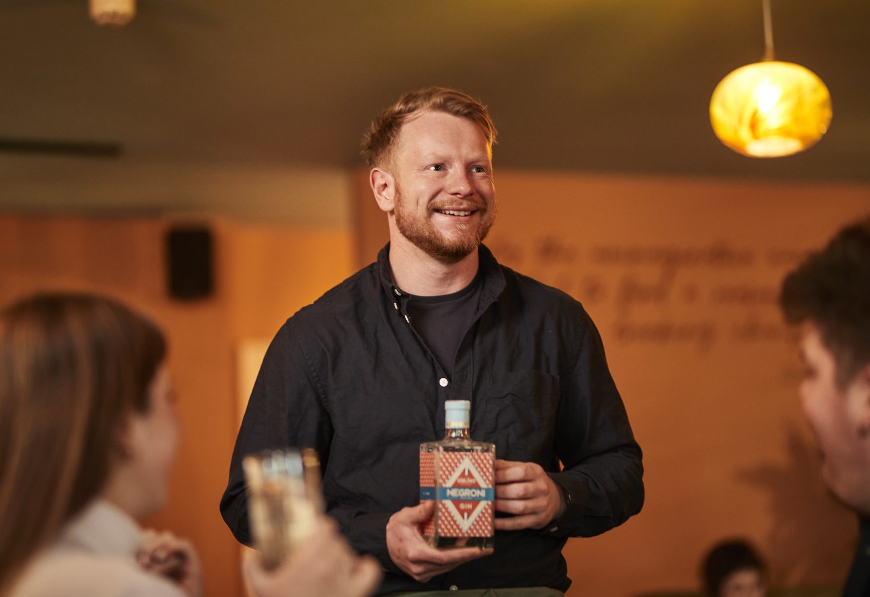 Felix holding a bottle of Sibling Gin.