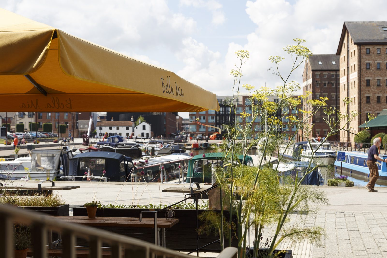 A dining area with a waterfront view with blue skies overlooking the Gloucester Docks.